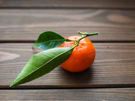 Mandarin with green leaves on wood tableの写真素材