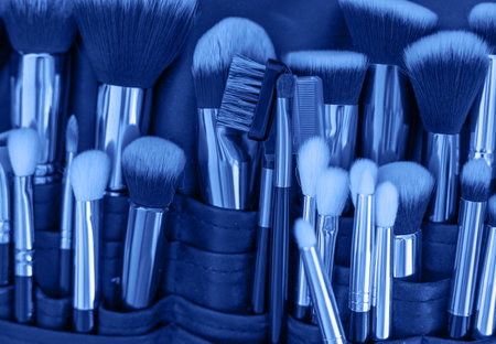 Professional makeup brushes and tools, make-up products set. Image monochrome toned. Color of the year. Beautiful blue background for designの写真素材