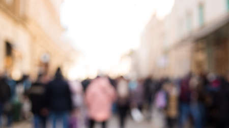 Blurred background. Blurred people walking through a city street. The photo is made out of focus, no faces are recognizableの写真素材