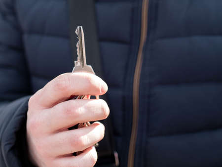 A man's hand holds the keys