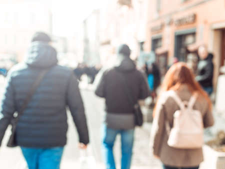 Blurred background. Blurred people walking through a city street. The photo is made out of focus, no...