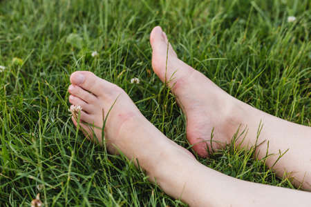 Close up of female legs lying on the grass in a parkの写真素材