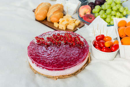 Picnic at the park on the grass: pie, tablecloth, fruits and vegetables