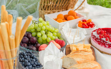 Closeup of picnic basket with flowers and different fruits and foodの写真素材