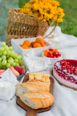 Closeup of picnic basket with flowers and different fruits and food