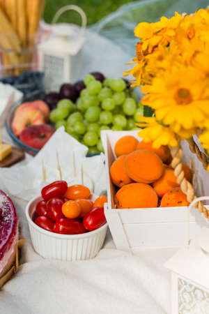 Closeup of picnic basket with flowers and different fruits and foodの写真素材
