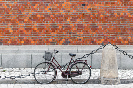 Bicycle with basket near the red brick wall. Eco friendly and urban lifestyle concept for transportation in old cityの写真素材