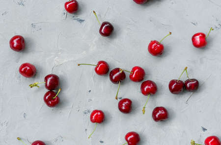 Ripe sweet Cherry with water drops on gray stone table. Top view. Rustic style. Food banner, flat...