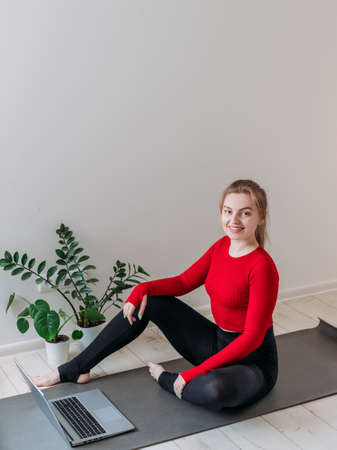 Girl practicing yoga at home. Woman is watching video on the internet and repeating the tasks....