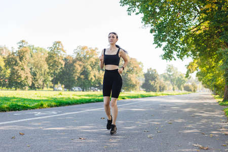 Athletic young happy woman runing in the park jogging in the morning for lifestyle health. Outdoor workout. Sport and healthy active lifestyle concept.の写真素材