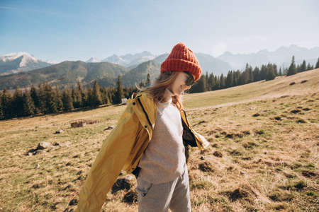 Young blond woman with sunglasses dancing in mountains. Freedom, happiness, travel and vacations...