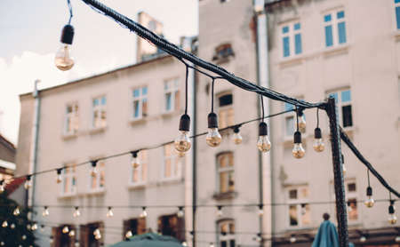 Decorative Outdoor Street electric garland against the sky in the garden, old townの写真素材