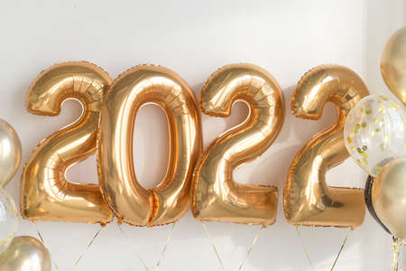 From above of gold number balloons showing 2022 year. Happy New year eve celebration. Balloon text...