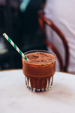 Chocolate cocktail with ice and paper traw. Cooling drinks, desserts in the summer heat. Order in...