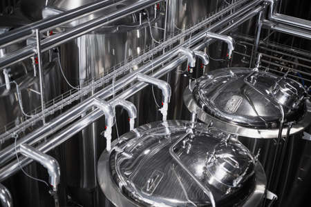 Modern Beer Factory. Steel tanks for beer fermentation and storage. Brewery. Modern beer plant with...