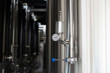 Pressure on pressure gauge on industrial machine in factory. Modern Beer Factory. Steel tanks for beer fermentation and storage.の写真素材