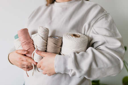 Handmade macrame braiding. Accessories in the form of macrame in womans hands. Baner copy space. Different types of threadの写真素材