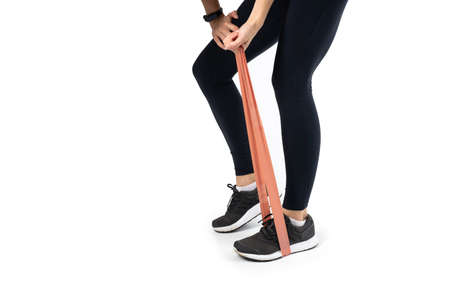 Sportswoman exercising with resistance band on white background. Attractive brunette woman in...