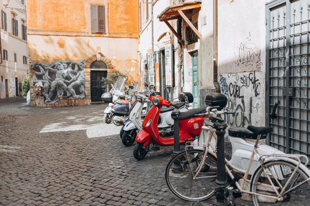 Rome, Italy April 4, 2022 - Cozy old street in Trastevere in Rome, Italy. Architecture and landmarks of Rome. Bright many scooters are parked on the city streetのeditorial素材