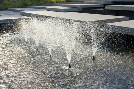 Fountain in the summer city park. Water jets in the fountain.の写真素材