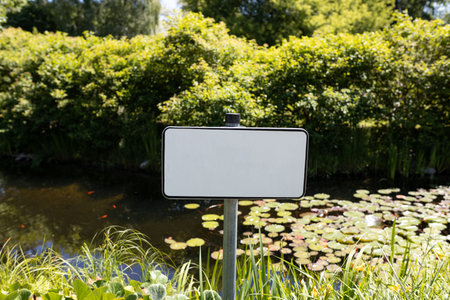 Blank signboard outdoors. Small forest fishing pond. Dangerous river swimming accident. Closeup...