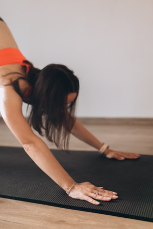 Young attractive woman practicing yoga, doing Downward facing dog exercise, adho mukha svanasana pose. Workout sport concept.の写真素材