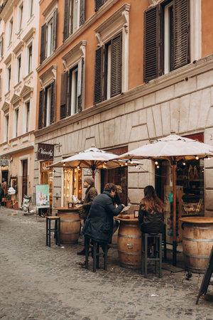 Rome, Italy - April 07, 2022, Tourists in a charming restaurant terrace in the city center of Rome. Typical street in Italy. People dining in Italian pizzeria restaurantのeditorial素材