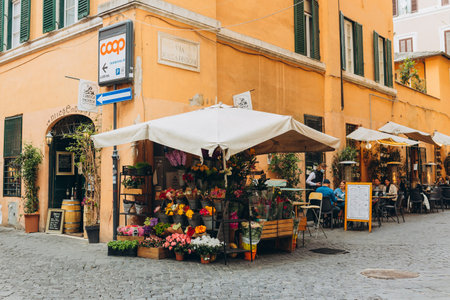 Rome, Italy - April 07, 2022, Fresh flowers for sale at a Italian flower market in Rome, Italy. Typical street in Italy. People dining in Italian pizzeria restaurantのeditorial素材