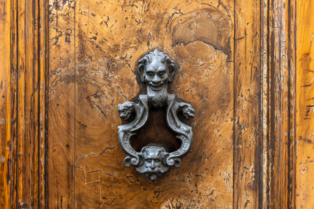 Metal antique door knocker, Rome, Italy. An old decorated vintage door with metal door handle