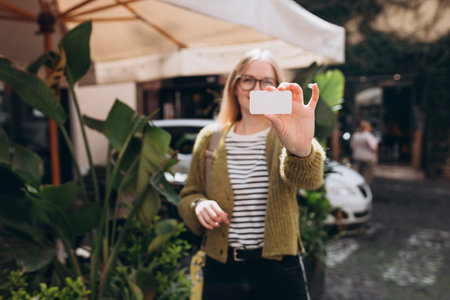 Happy woman hold one blank business card. close up womans hand showing white blank visiting card. Resolution and high quality beautiful photoの写真素材