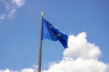 Official flag of the European Union. National Europe flag waving against the blue sky.