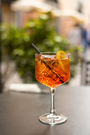 Spritz Cocktail. Alcoholic beverage based on table with ice cubes and oranges outdoors. Served...