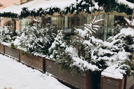 Christmas street decorations and falling snow in the city