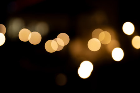Decorative string lights at night time, Defocused Background, night city backdrop, party time with Yellow bokeh balls.の写真素材