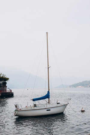 White sailing boat on lake Como. Water sports. The concept of a luxurious lifestyle, mountain...
