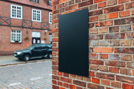 Blank black billboard sign mockup in the urban environment. Clear urban glued advertising canvas. Billboard advertisement advertiser on textured red wallの写真素材
