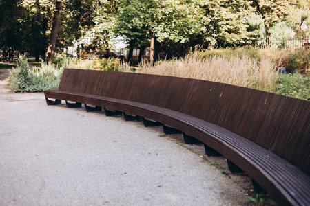 City park with Wood modern Park Bench. Geometry on nature and place to rest. Exterior empty park bench. Furniture in garden.の写真素材