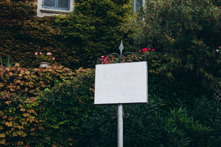 Information or advertisement white blank sign board mounted in urban park outdoor. Abstract empty rectangular white sign, rent or sale house conceptの写真素材