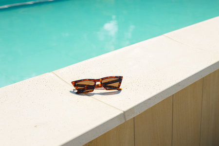 Summer holidays, travel and vacation concept. Brown funky sun glasses near swimming pool. Outdoor shotの写真素材