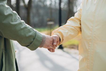 Two women friends or female partners meet on street. Handshake of Successful business women on the background of modern buildings, merger and acquisition concepts. Shaking hands to seal a dealの写真素材