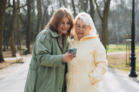 Women use smartphone to find what they are interested in outdoors. Searching information data on...