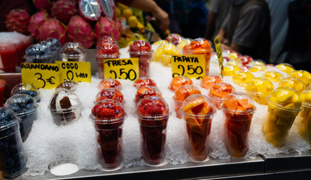 Blueberries, strawberries, coconut, pineapple, papaya in a plastic glass. Convenience, healthy lifestyle. Variety of fruits at farmers marketの写真素材