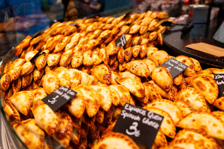 An empanada is a type of pastry baked or fried in Hispanic cultures. Mix set empanadas on outdoors bazar. Closeup of baked snack empanada at market, popular Spanish street foodの写真素材
