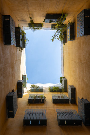 View up into the sky from the courtyard well in Barcelona, Spain. Bottom view. Modern balcony with plantsの写真素材