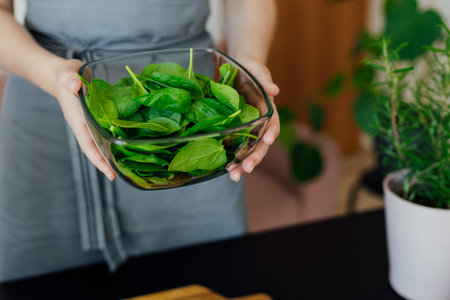 Close up woman cooking salad at home kitchen. Process of cooking healthy food, vegetable salad concept. Menu, recipe book bannerの写真素材