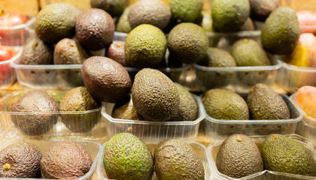Showcase with fresh organic avocado in supermarket. Plastic boxes in the shop of greengrocer at market.の写真素材