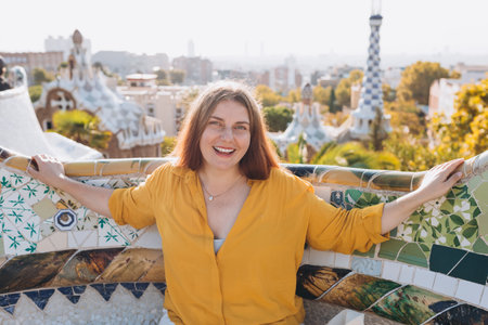 Woman 30s tourist having fun visiting famous Guell park in Barcelona. Concept of travel, tourism and...