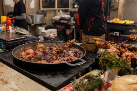 Grilled sausages, pork in street market in a medieval fair. Sausages and pork ready to eat. Festival of street food and meat. Selling traditional hot food at the Christmas Fair. Chief cooking meatの写真素材