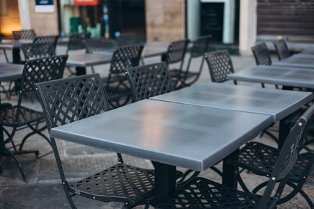 Modern outdoor terrace with seating arrangement. Fashionable outdoor restaurant tables, summer time. Tables and chairs at sidewalk cafe. Touristic setting, cafe table, sidewalk cafe furnitureの写真素材