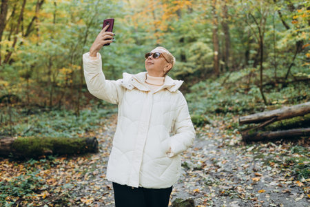 No communication coverage, lost contact signal device. Mature woman got lost an internet connection on phone while hiking alone in the forest. Travel and people banner. High quality photoの写真素材